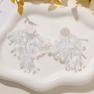 Handmade white beaded fringe flower earrings DIY apparel accessories detail shot, elegant style.