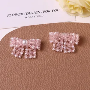 Detailed close-up of handmade pink crystal beaded bow accessories with pearls for diy crafts.