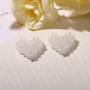 Clear close-up of handmade transparent beaded heart DIY accessories for cute jewelry making.