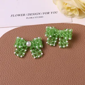 Handmade green beaded bow DIY accessories, elegant detail shot for earrings or hair decor.
