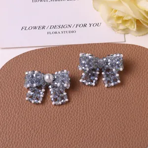 Close-up detail of woven beaded bow jewelry making accessories with pearl and macaron crystals.
