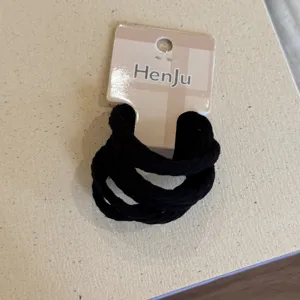 Close-up detail of black elastic hair ties set with packaging card for daily hair styling.
