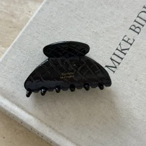 Pince à cheveux noire en acétate pour femmes, accessoire élégant pour coiffure chic au quotidien.