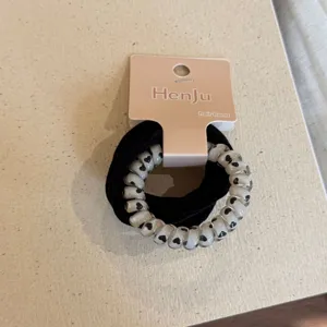 Detail view of the cute hair tie set featuring a black band and heart print telephone cord.