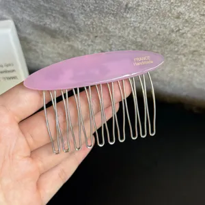 Detailansicht eines rosa Acetat-Haarkamms mit Metallzinken, elegantes Haarstyling-Zubehör.