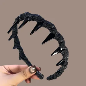 Detailed close-up of a black denim wrapped hair hoop with plastic teeth, versatile hair accessory.