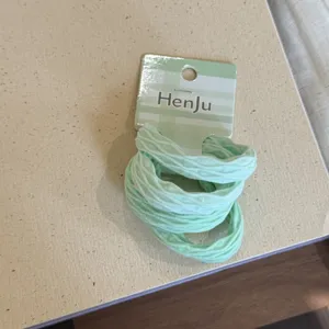 Light green elastic hair ties set for women, sweet scrunchies with card packaging detail.