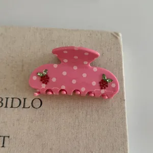Pink polka dot hair claw clip with crystal strawberry design for women and girls styling.