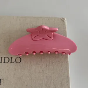 Pink hair claw clip close-up, floral design hair accessory for women styling and daily wear.