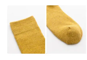 Close-up detail shot of women's warm yellow knit loop socks, showcasing cuff and toe texture.