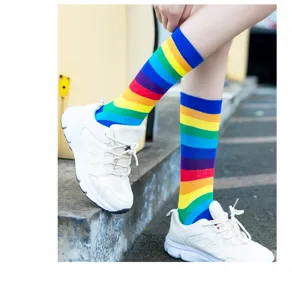 Vue détaillée de chaussettes rayées arc-en-ciel portées avec des baskets, look décontracté.