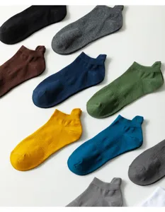 Dettaglio in primo piano di calzini corti in cotone colorato e tinta unita disposti ordinatamente.