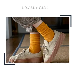 Women solid color ribbed mid tube socks paired with suede platform casual shoes style.