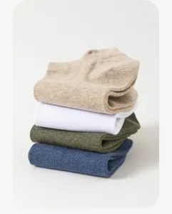 Nahaufnahme eines Stapels kurzer Herrensocken in vier verschiedenen Farben, atmungsaktiv.