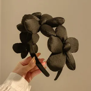 Black floral headband detail, chic satin flower design, padded high crown hair accessory for women.
