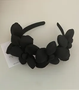 Black fabric floral headband detail view, French style chic flower hair hoop accessory.