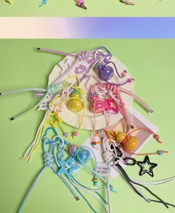 Detailed shot of colorful woven rope calabash keychains and star charms for DIY bag decoration.