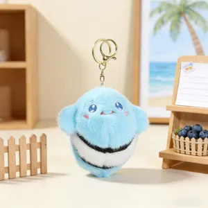 Close-up detail of the cute blue marine animal plush keychain with embroidered face and stripes.
