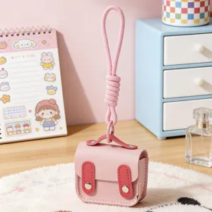 Mini custodia per auricolari in ecopelle rosa con cordino intrecciato portachiavi.