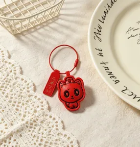 Leather keychain detail view featuring a cute red cat design and exam success blessing tag.