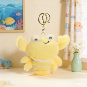 Detail van gele pluche krab sleutelhanger met zachte textuur en metalen ring voor tasornament.