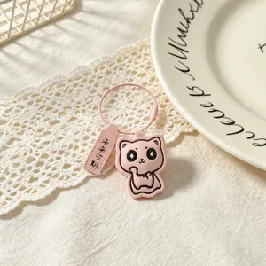 Detail closeup of cute pink leather cat keychain with motivational tag for student gift.