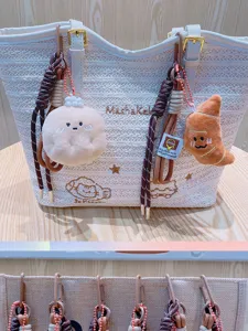 Woven straw tote bag with cute plush food keychains, stylish shoulder bag for daily casual use.