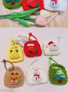 Close-up details of cute knitted mini coin purses with Christmas cartoon charms and keychains.