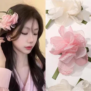 Vue détaillée de la pince à cheveux fleur en mousseline 3D faite main au charmant design rose.