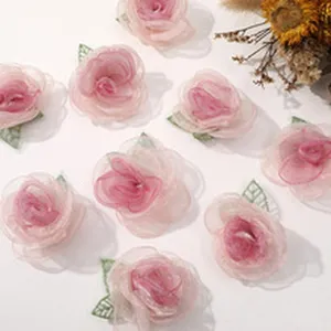 Vista dettagliata di fiori in rete rosa fatti a mano con foglie verdi, perfetti per il fai da te.