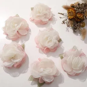Vista di dettaglio di accessori floreali in rete fatti a mano con perle rosa e bianche.