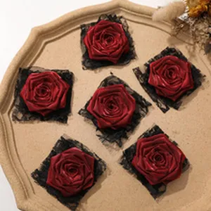 Fiori di rosa in raso rosso fatti a mano con rete nera per accessori per capelli e corsage.