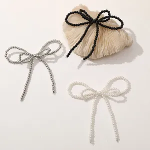 Detail view of handmade beaded bow accessories in black, silver, and white pearl styles.