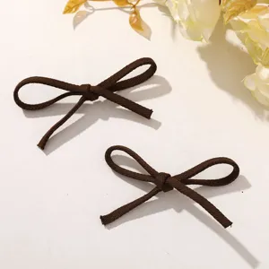 Brown fabric bow DIY accessory detail, cute hair clip and shoe flower decoration element.