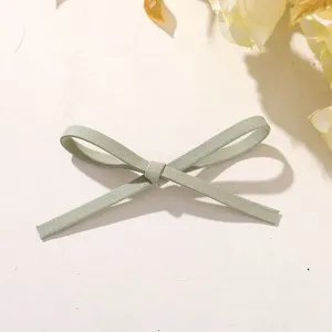 Light green fabric bow DIY accessory detail shot, showing exquisite knot and soft material texture.