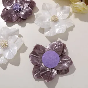 Close-up detail of shiny silk fabric flower accessories, ideal for DIY clothing, hair clips.