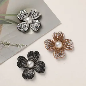 Close-up detail of sparkling rhinestone four-petal flower DIY accessories with pearl center.