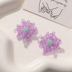 Vue rapprochée détaillée d'accessoires de bijoux de fleurs de perles de cristal violet fait main.