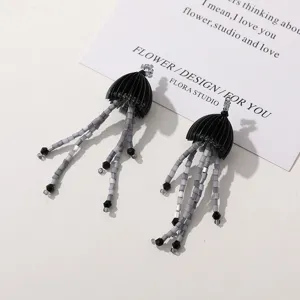 Detailed close-up view of unique black grey jellyfish beaded tassel earrings with fine beadwork.