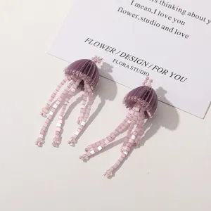 Close up detail view of handmade purple beaded jellyfish tassel earrings with cute design.