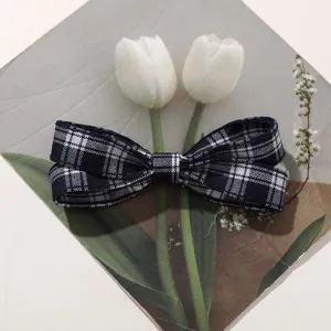 Detailed close-up shot of the classic dark blue and white plaid fabric bow hair accessory.