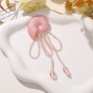 Nahaufnahme von rosa Harz-Muschelschmuck mit Perlenfransen-Detail für DIY-Bastelarbeiten.