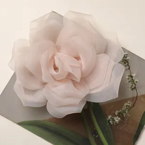Primo piano di un delicato fiore di rosa in tessuto organza rosa, perfetto per lavori.