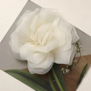 Dettaglio rosa in chiffon bianco, primo piano dell'accessorio in tessuto per bricolage e decoro.