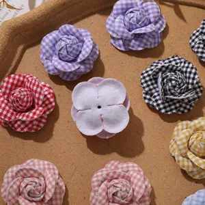 Detailed close-up of colorful checkered fabric camellia flowers for DIY accessories.
