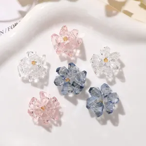 Close-up detail of clear, pink, and blue crystal flower DIY accessories and craft charms.