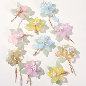 Close-up of handmade colorful magnolia flower DIY hair accessories charms with green leaves.
