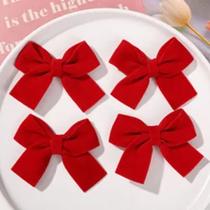 Red velvet bow hair clips detail shot, elegant fabric hair accessories for women and girls.