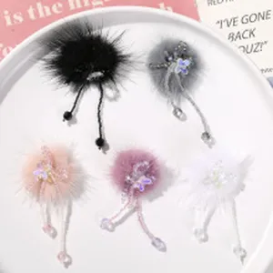 Detailed view of handmade fluffy pom pom hair clips with elegant beaded tassels and cute charms.