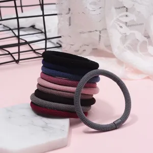 Close-up detail of thick elastic hair ties in multiple colors, showing soft knitted texture.
